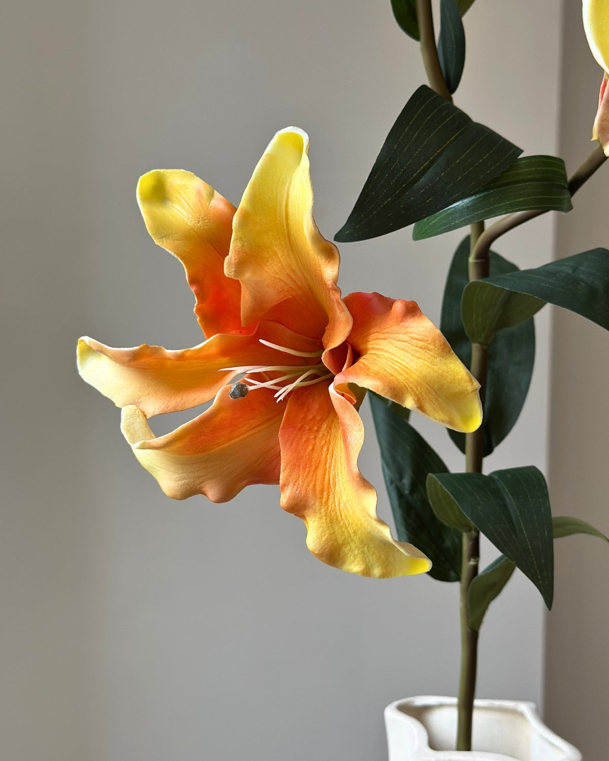 Stor, kunstig lilje i orange nuancer