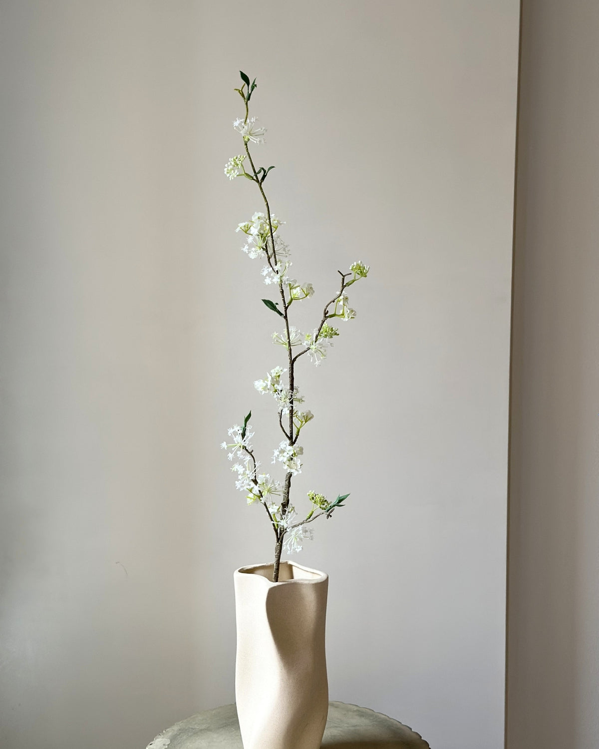 Kunstig, høj, hvid snow willow gren i en sandfarvet vase