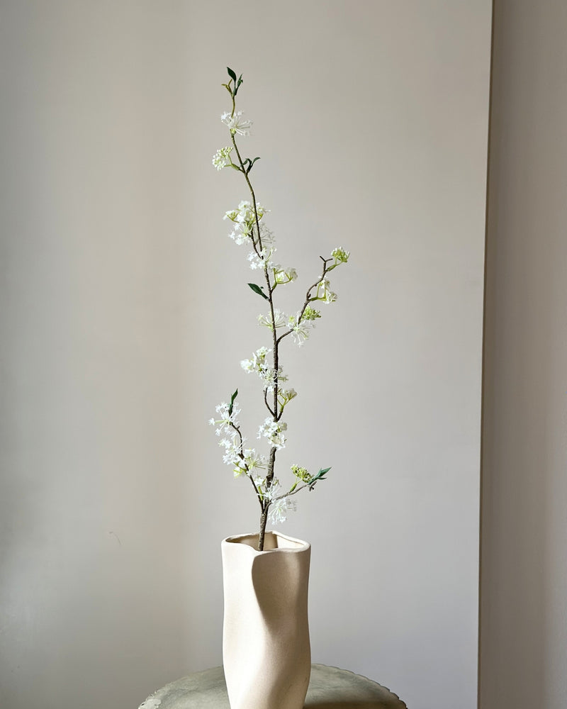 Kunstig, høj, hvid snow willow gren i en sandfarvet vase