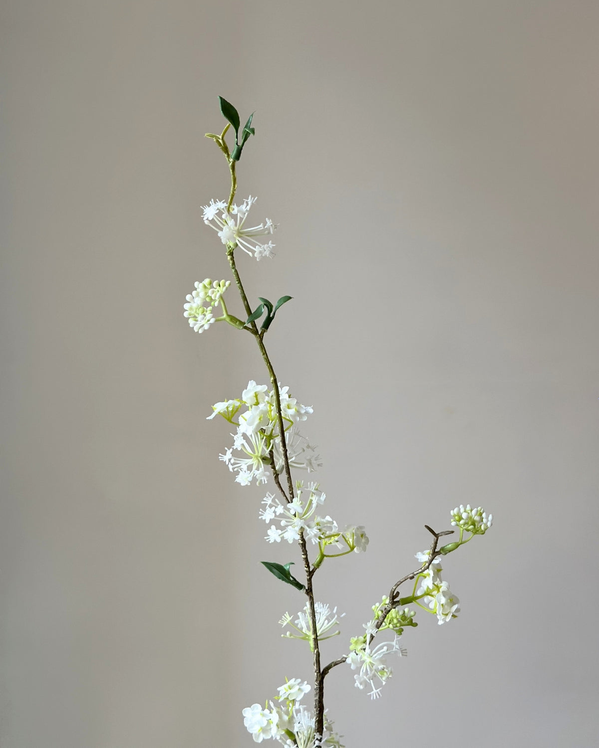 Kunstig, høj, hvid snow willow gren i en sandfarvet vase