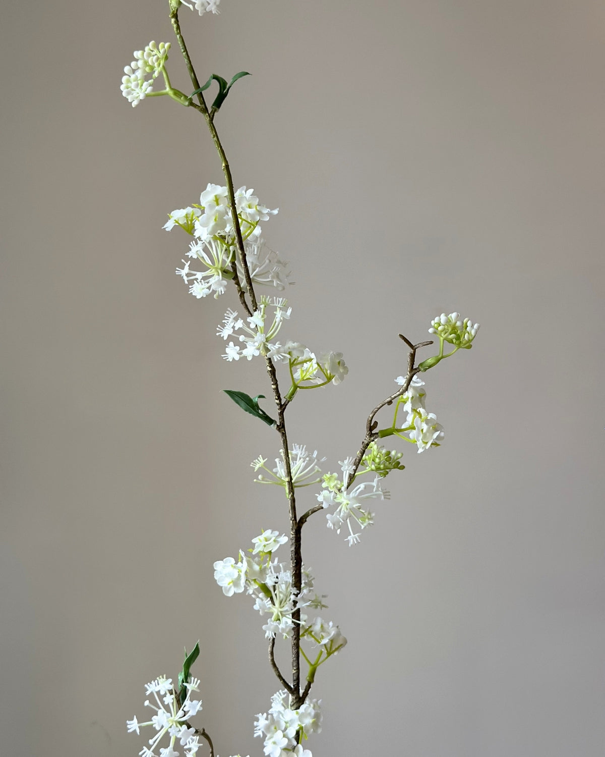 Kunstig, høj, hvid snow willow gren i en sandfarvet vase