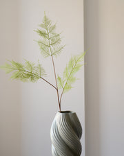 En luftig og elegant bregnegren, der med sine fine, fjerlette blade bringer bevægelse og struktur ind i enhver buket eller dekoration.&nbsp;Den støvede grønne nuance og detaljerede bladmønster giver et naturtro udtryk, der spiller smukt sammen med både farverige blomster og neutrale toner. Med sin fleksible stilk er bregnen nem at forme og placere – perfekt som fyld eller kontrast i en blomstersammensætning.

Et tidløst element, der tilfører lethed og frodighed – og som holder sig smuk helt uden vand.

Stil