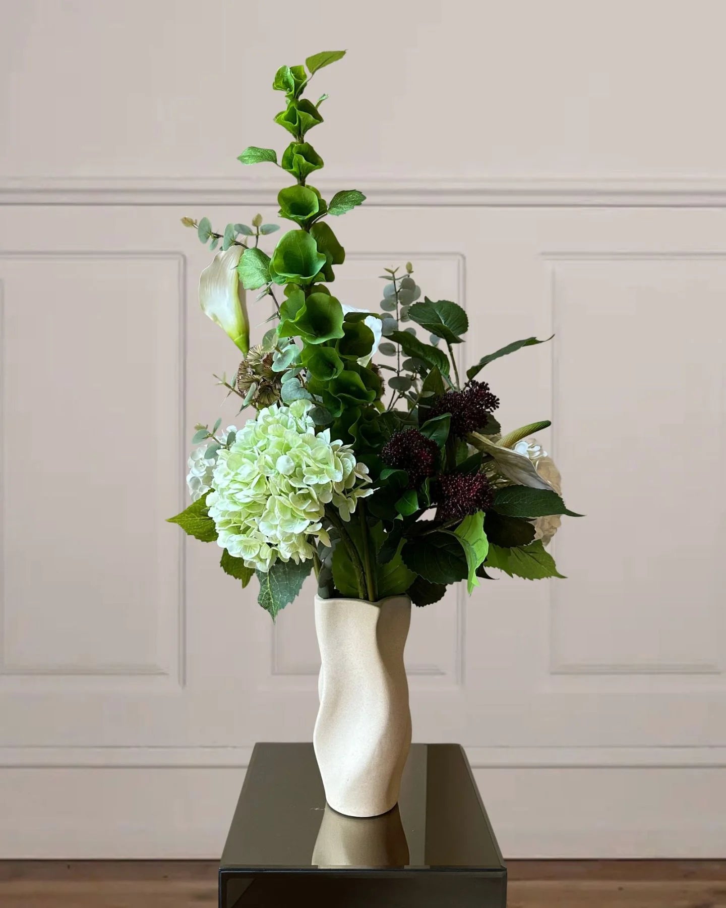 Skab en tidløs og elegant stemning med denne smukke evighedsbuket, der kombinerer luksuriøse blomster og naturinspirerede detaljer. De fyldige Hortensiaer og den karakteristiske grønne Bells of Ireland suppleres smukt af de elegante Liljer og de delikate Skabioser.


Farvesammensætningen byder på en harmonisk palet af hvide, grønne, bordeaux og brune nuancer, der giver et naturligt og sofistikeret udtryk. Perfekt som en stilfuld dekoration i hjemmet, på kontoret eller som en gave, der holder for evigt.