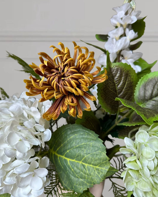 En karakterfuld og sofistikeret efterårsbuket, hvor hvide og grønne hortensiaer, anthurium og ridderspore danner et smukt udgangspunkt. De elegante bregneblade tilfører lethed og en fornemmelse af ro, mens bukettens midtpunkt er den rustfarvede kaktus dahlia, der med sine spidse kronblade og varme nuancer skaber kontrast og balance.&nbsp;

Buketten indeholder:
2x Hortensia
1x Ridderspore
1x Anthurium
1x Efterårs Hortensia Gren
2x Bregne
1x Kaktus Dahlia