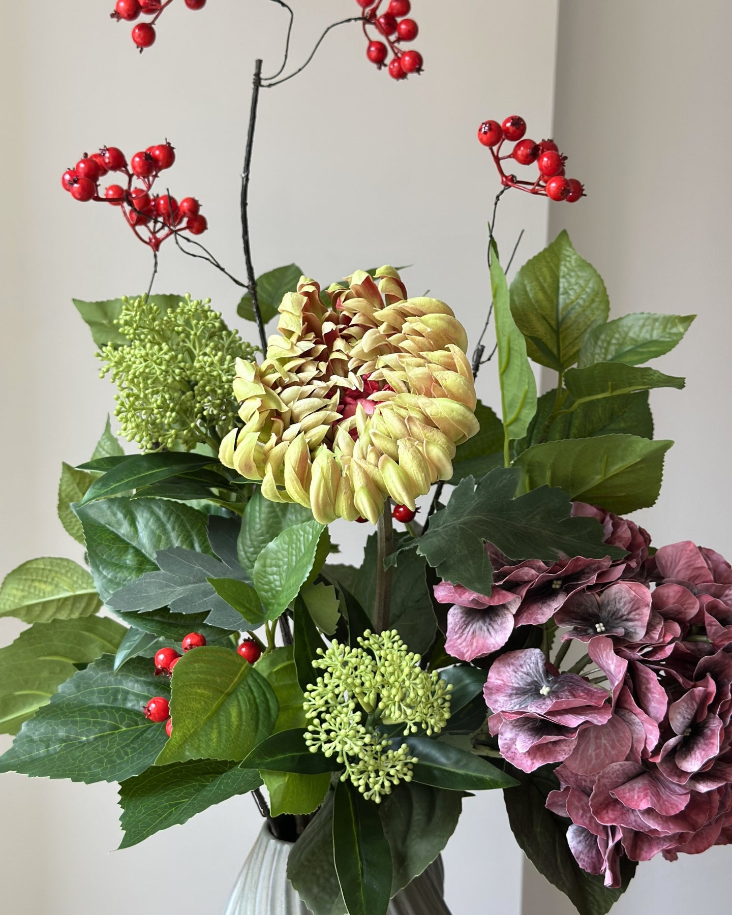 Buket af kunstige blomster med bær og grønne blade