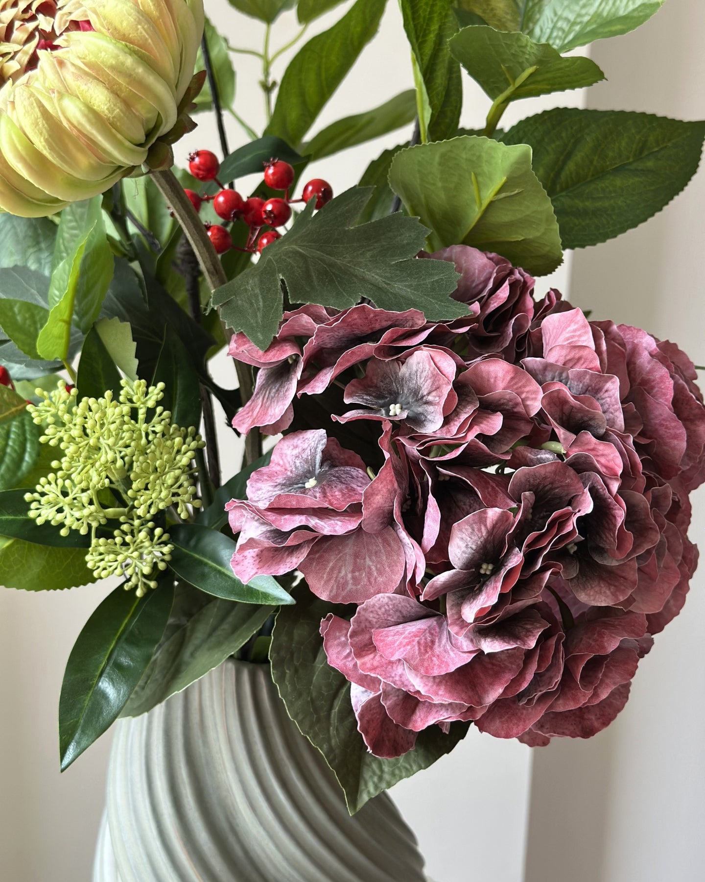 Buket af kunstige blomster med bær og grønne blade