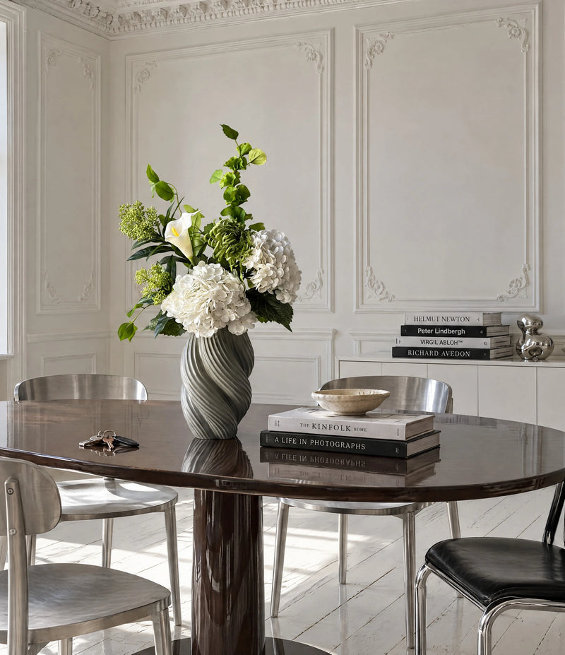 White Colonnade buket fra Bloomgaard med hvide hortensia, calla og grøn krysantemum i en grå vase på et spisebord i en lys københavnerlejlighed