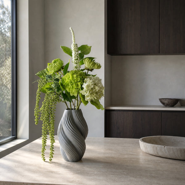 Kunstig blomsterbuket med groenne hortensiaer placeret på koekkenbord