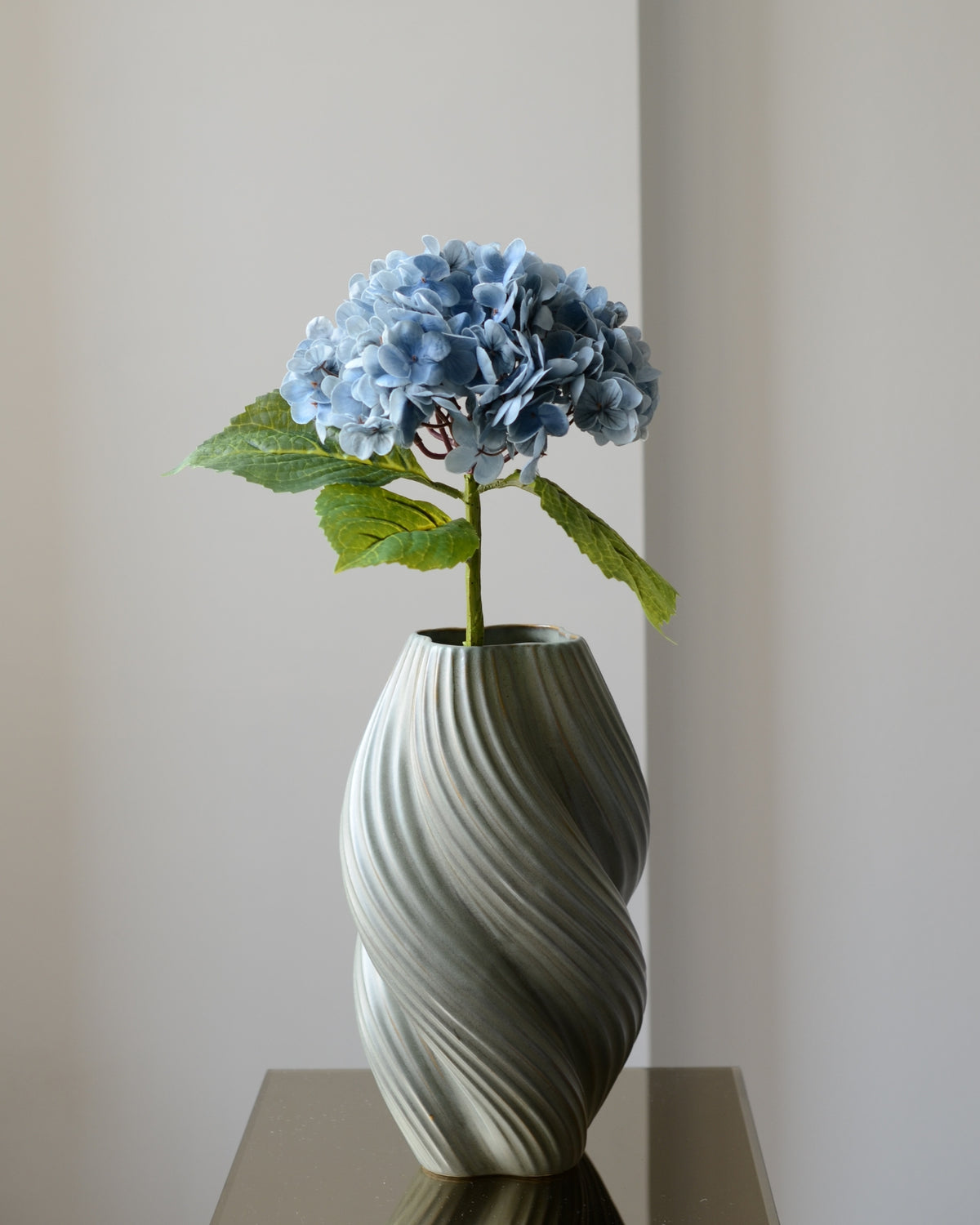 Den kunstige hortensia i blå er en iøjnefaldende blomst, der tilføjer et elegant element til en buket. Med sit fyldige blomsterhoved i smukke, rene nuancer skaber den en indbydende atmosfære. Den detaljerede blomst og de grønne blade giver et naturligt og realistisk udtryk, mens den langvarige kvalitet gør den til en vedligeholdelsesfri løsning.

Stilken måler 49 cm.