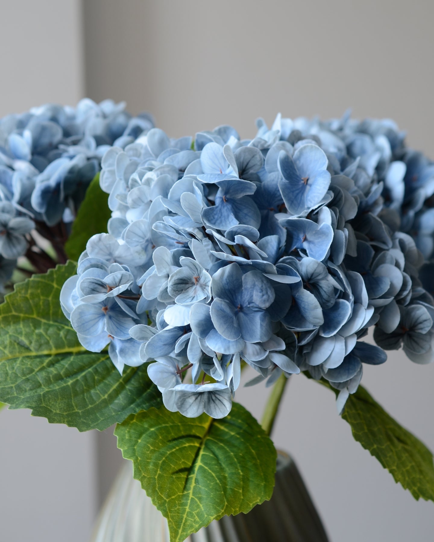 Den kunstige hortensia i blå er en iøjnefaldende blomst, der tilføjer et elegant element til en buket. Med sit fyldige blomsterhoved i smukke, rene nuancer skaber den en indbydende atmosfære. Den detaljerede blomst og de grønne blade giver et naturligt og realistisk udtryk, mens den langvarige kvalitet gør den til en vedligeholdelsesfri løsning.

Stilken måler 49 cm.