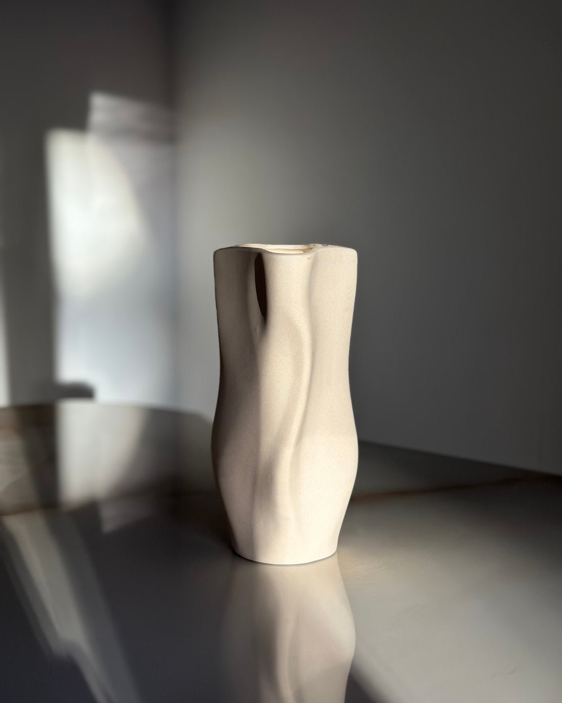 Nordic Vase er en eksklusiv porcelænsvase med et organisk og minimalistisk design, inspireret af naturens bløde former. Vasen har en mat, sandfarvet overflade, der fremhæver dens bølgende konturer og giver et skulpturelt udtryk.

Perfekt til både kunstige og friske blomster, men også smuk som en selvstændig dekoration. Dens neutrale farvetone og taktile overflade passer perfekt ind i moderne, skandinaviske hjem, hvor æstetik og funktionalitet går hånd i hånd.