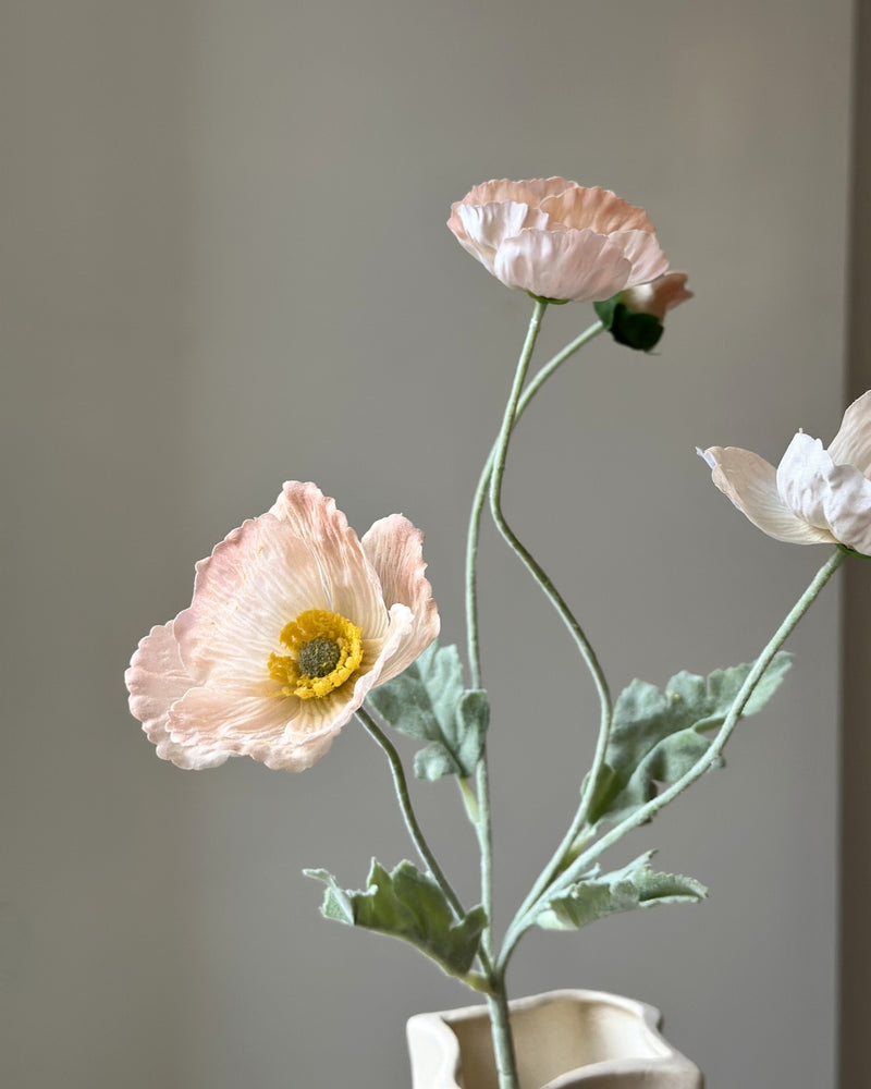 Fersken farvede, kunstige valmuer. Tre udsprungne hoveder og en knop