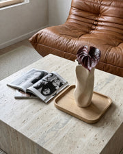 Kunstig dybrød anthurium blomst i en beige vase