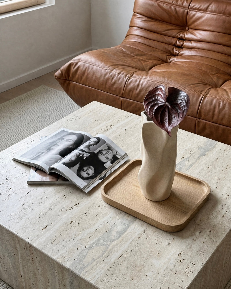 Kunstig dybrød anthurium blomst i en beige vase