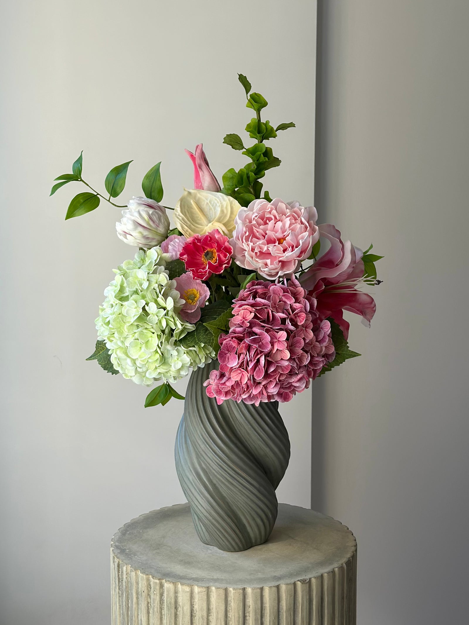 Summer Meadow kunstig buket med lyserød peon, koralrød valmue og grøn og lyserød hortensia i grå snoet vase